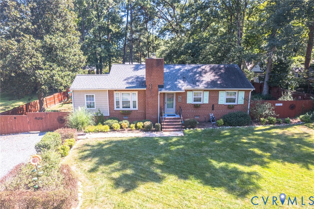 Brick exterior with siding accents, mature landscaping, and a well-maintained lawn