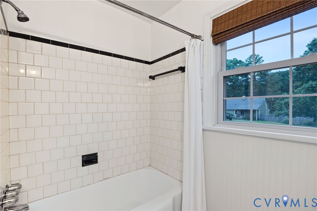 White subway tile shower surround with black accent trim