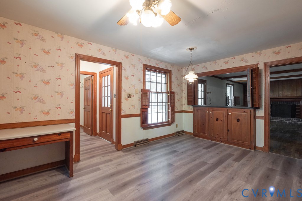 Wood-finish flooring throughout, built-in cabinetry with wood shutters, and wood trim detailing