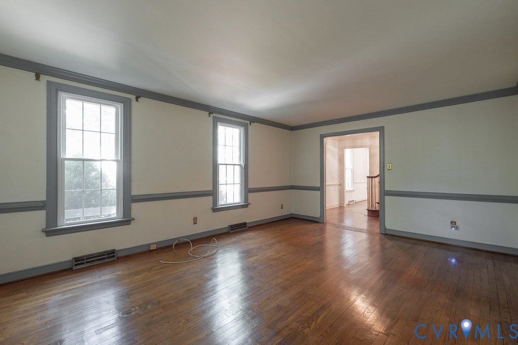 Hardwood flooring throughout, featuring neutral wall tones and decorative chair rail molding