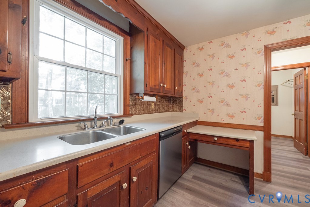 Wood-finish cabinetry with light countertops and a double basin sink