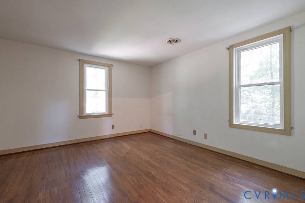 Hardwood flooring with neutral wall tones and two double-hung windows