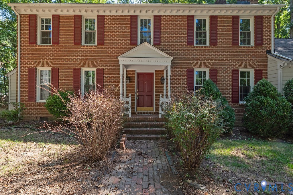 Brick exterior with white window trim and red shutters