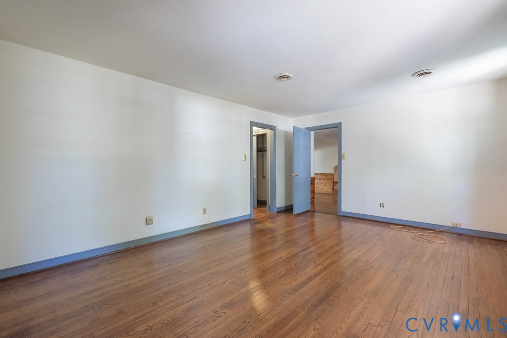 Hardwood flooring throughout with light-toned walls and contrasting trim