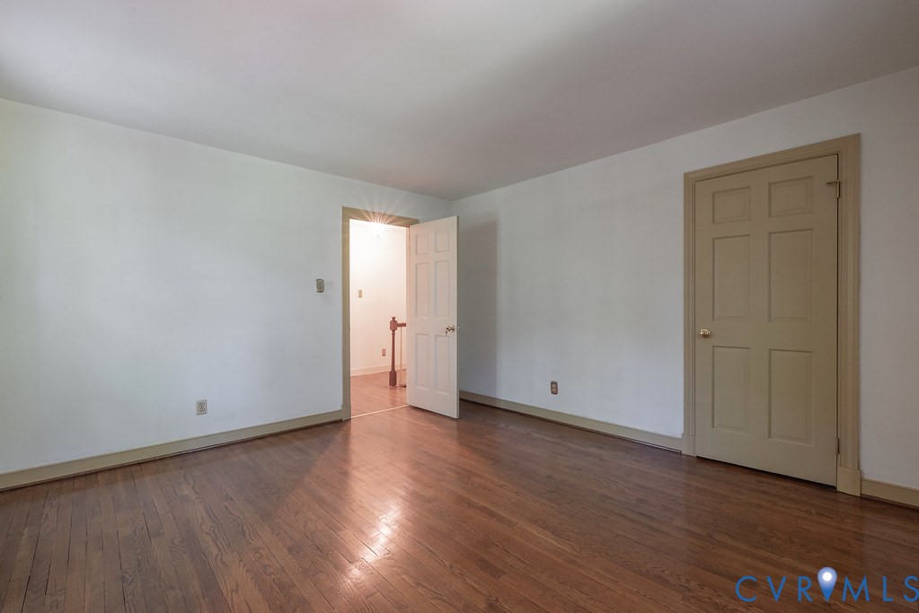 Hardwood flooring, painted interior doors, and white walls