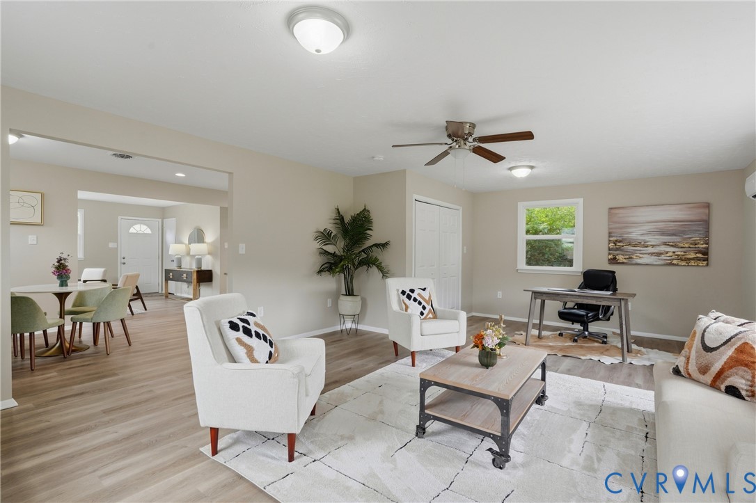 Spacious living area featuring wood-finish flooring, neutral wall tones, a ceiling fan, and recessed lighting