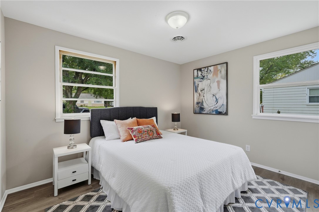 Light gray walls, white trim, wood-finish flooring, two windows, and a ceiling-mounted light fixture