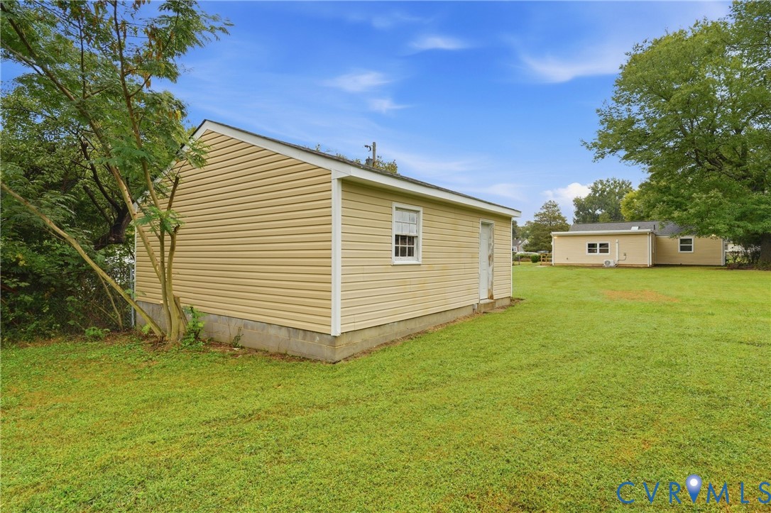 Detached structure featuring tan siding and a single window