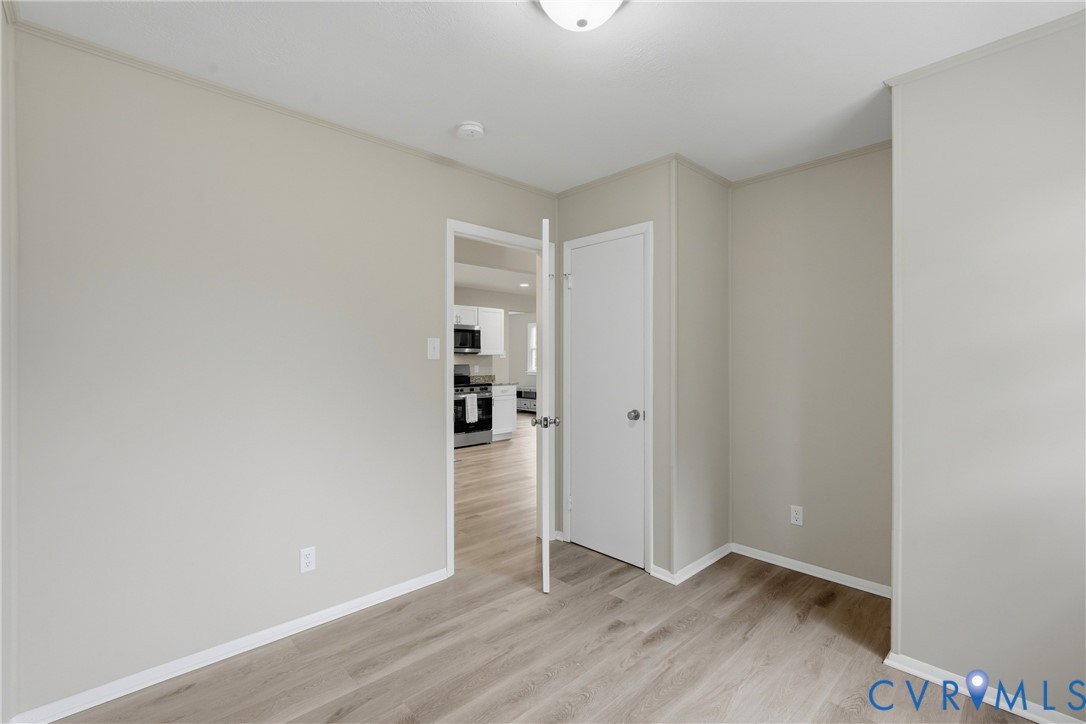 Wood-finish flooring, neutral wall tones, and overhead lighting