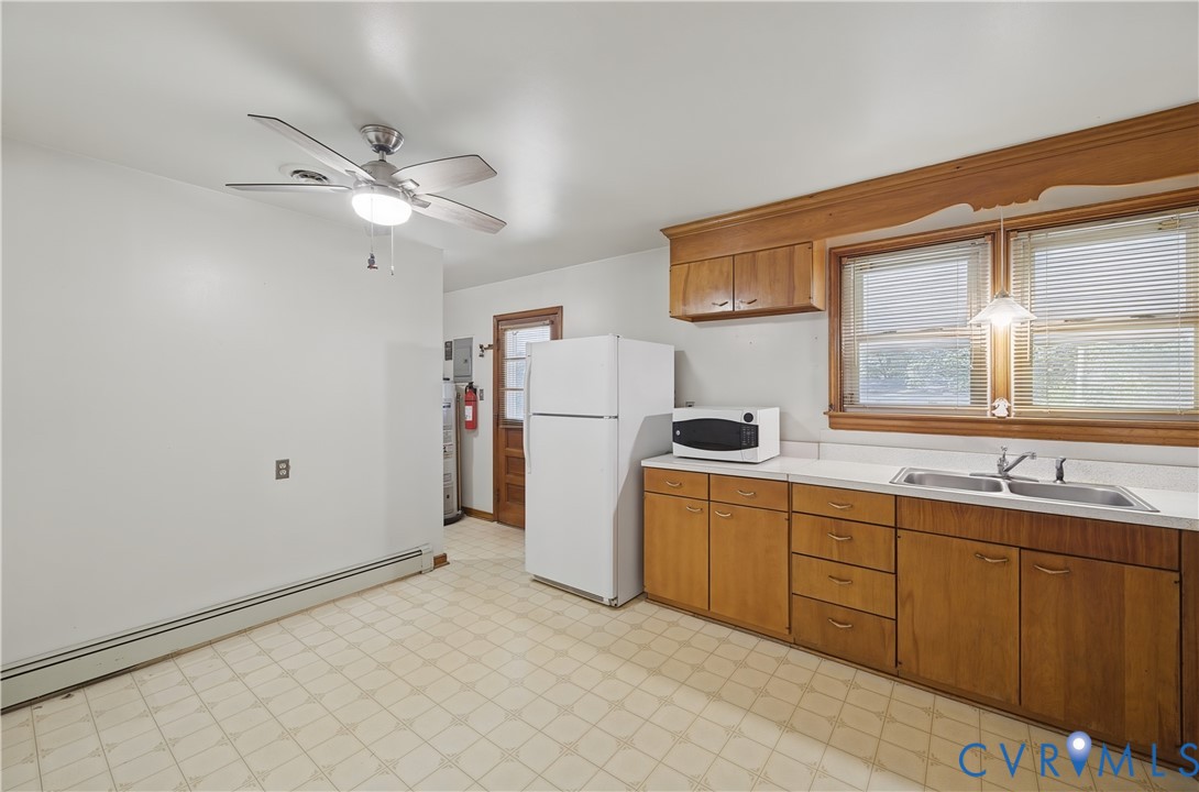 Spacious kitchen featuring wood-finish cabinetry, laminate countertops, and a stainless steel refrigerator