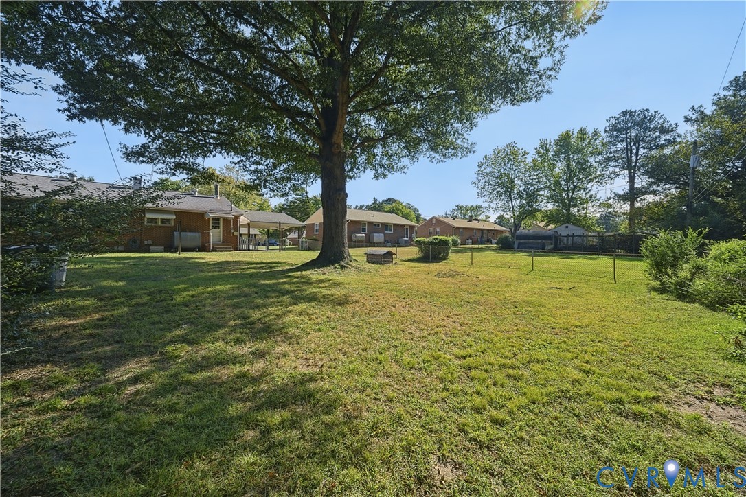 Expansive grounds featuring mature shade trees and lush lawn with multiple outbuildings, offering substantial acreage and versatile outdoor space