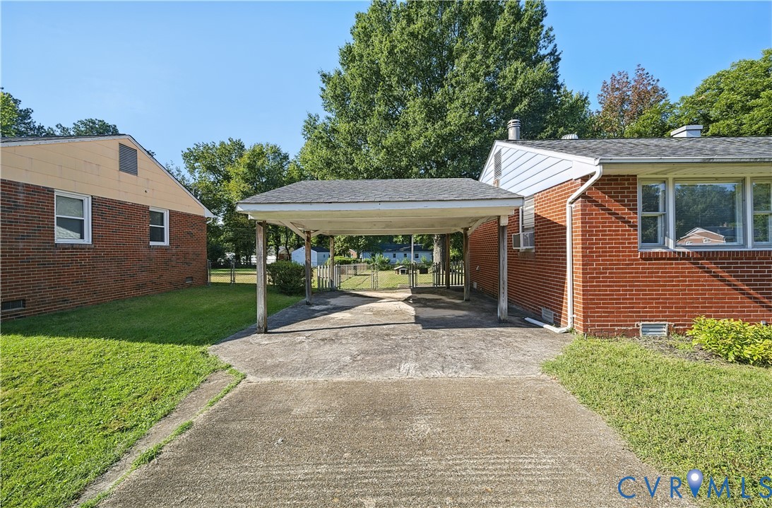 Brick exterior residence with a covered carport and a concrete driveway