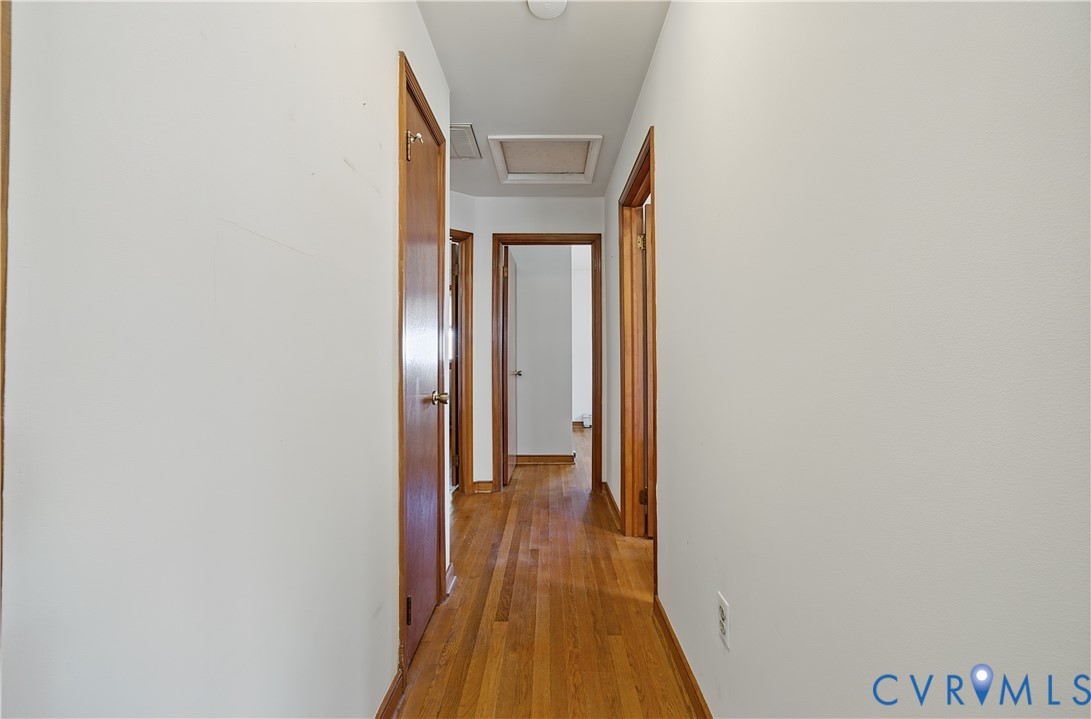 Hardwood flooring throughout, white painted walls, and wood interior doors