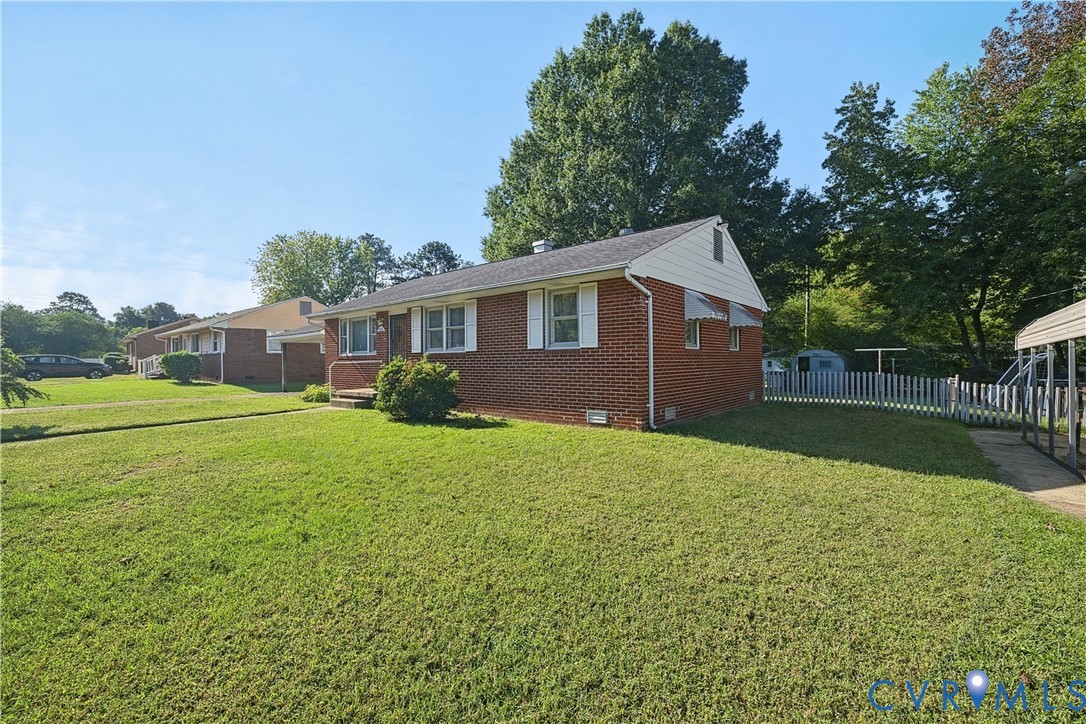 Brick exterior, white window shutters, front porch, mature trees, white picket fence