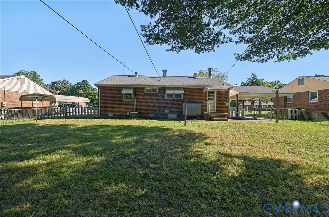 Brick exterior with a covered patio, rear entry, and a fenced area