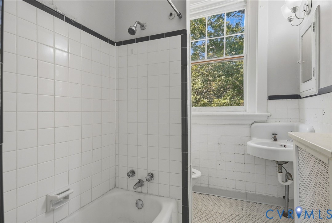 White tile shower surround with black accent trim
