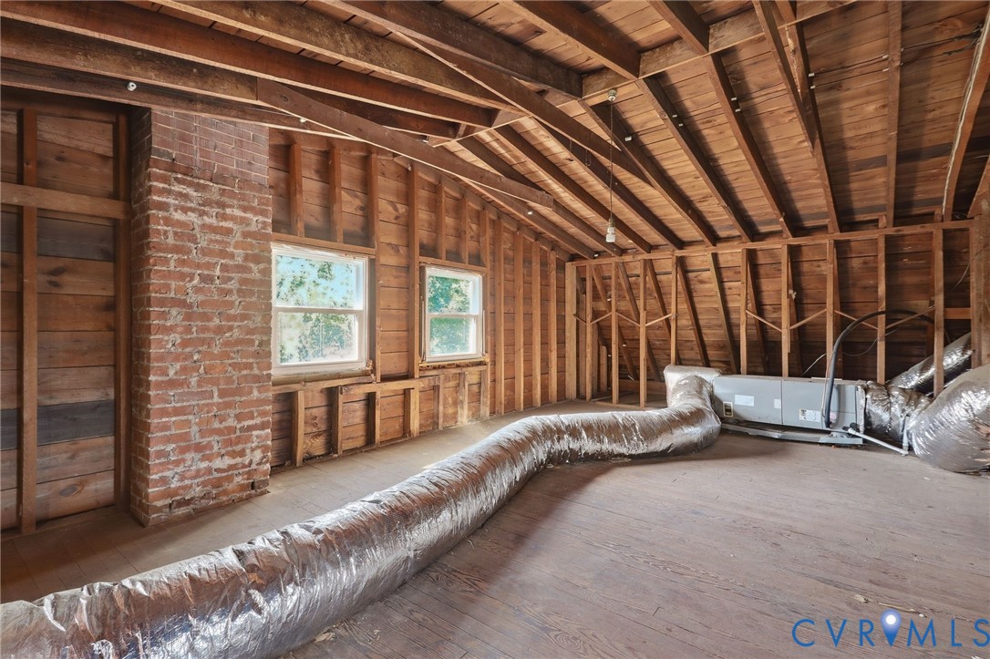 Exposed brick chimney and wood-plank flooring
