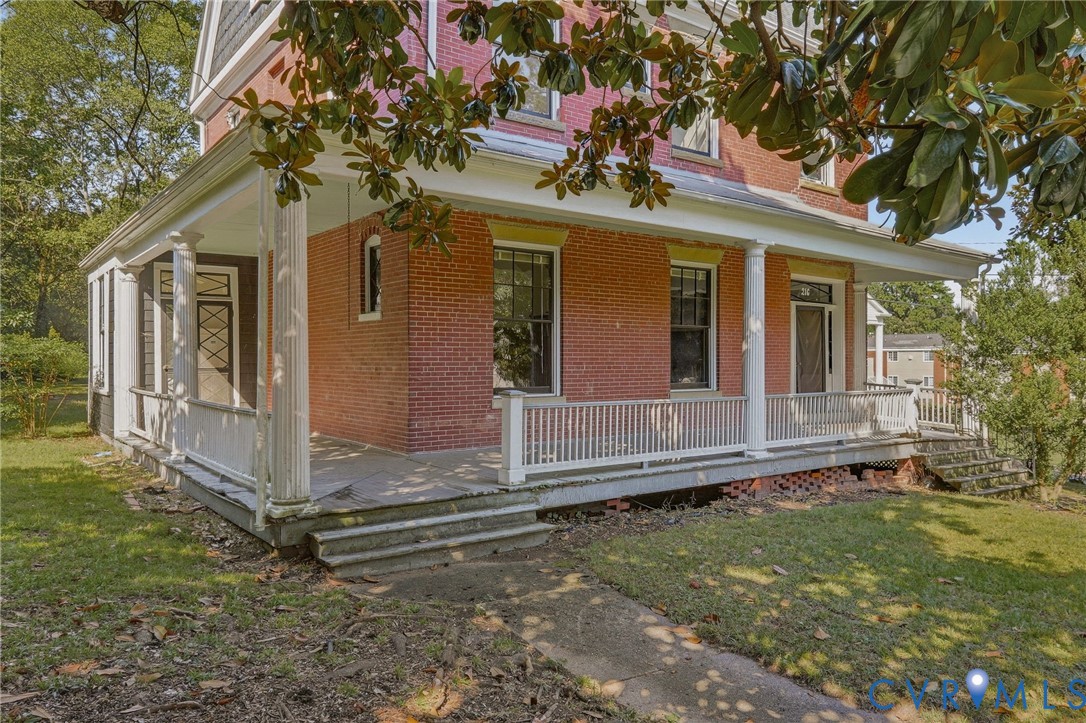 Brick exterior with a covered front porch, white columns, and white railing Brick exterior with a covered front porch, white columns, and white railing