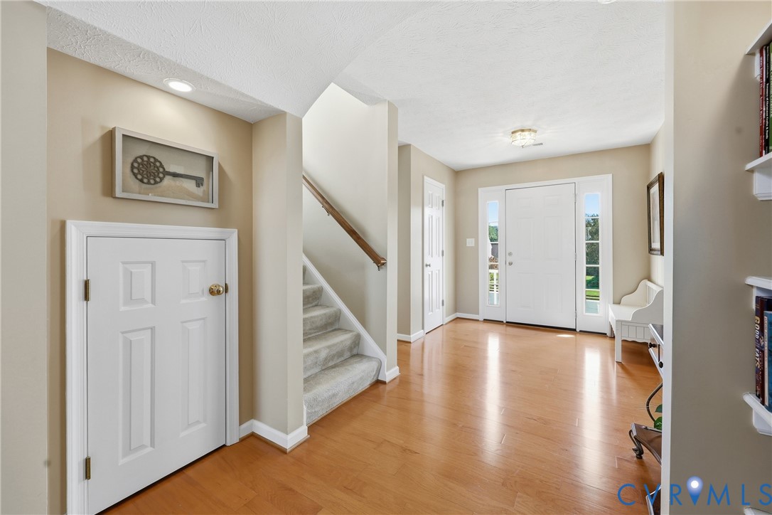 Hardwood flooring and a carpeted staircase create an inviting first impression upon entering the home Hardwood flooring and a carpeted staircase create an inviting first impression upon entering the home