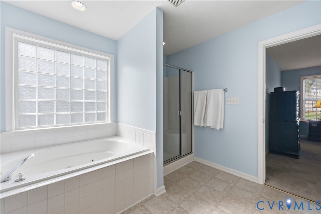 Relax in the jetted tub or enjoy the convenience of a separate shower in this spa-inspired ensuite bathroom