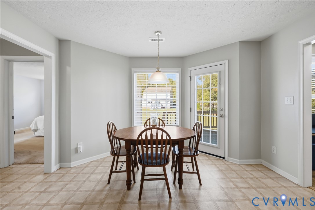 Bright breakfast nook surrounded by large windows, offering a cheerful spot for morning coffee or casual meals.