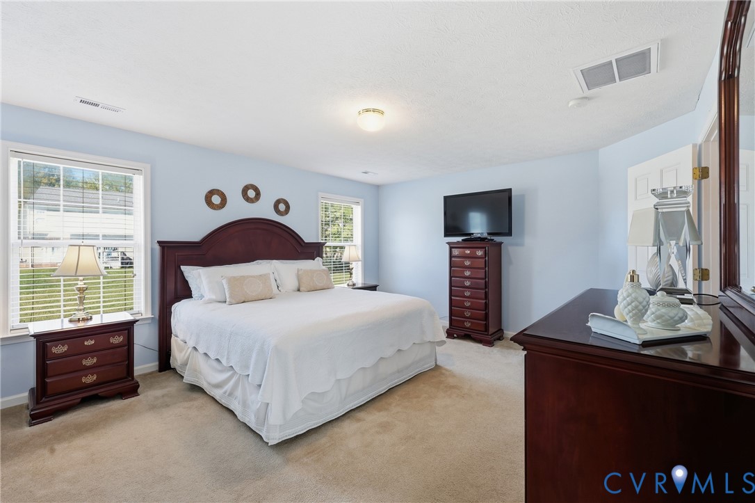 First-floor primary bedroom with plush carpeting, offering a comfortable retreat away from the upstairs bedrooms.