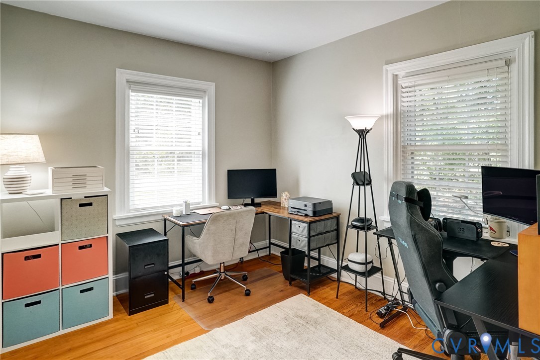 Bedroom 2, Hardwood flooring, two windows with blinds, light gray wall paint, white trim, and a white ceiling