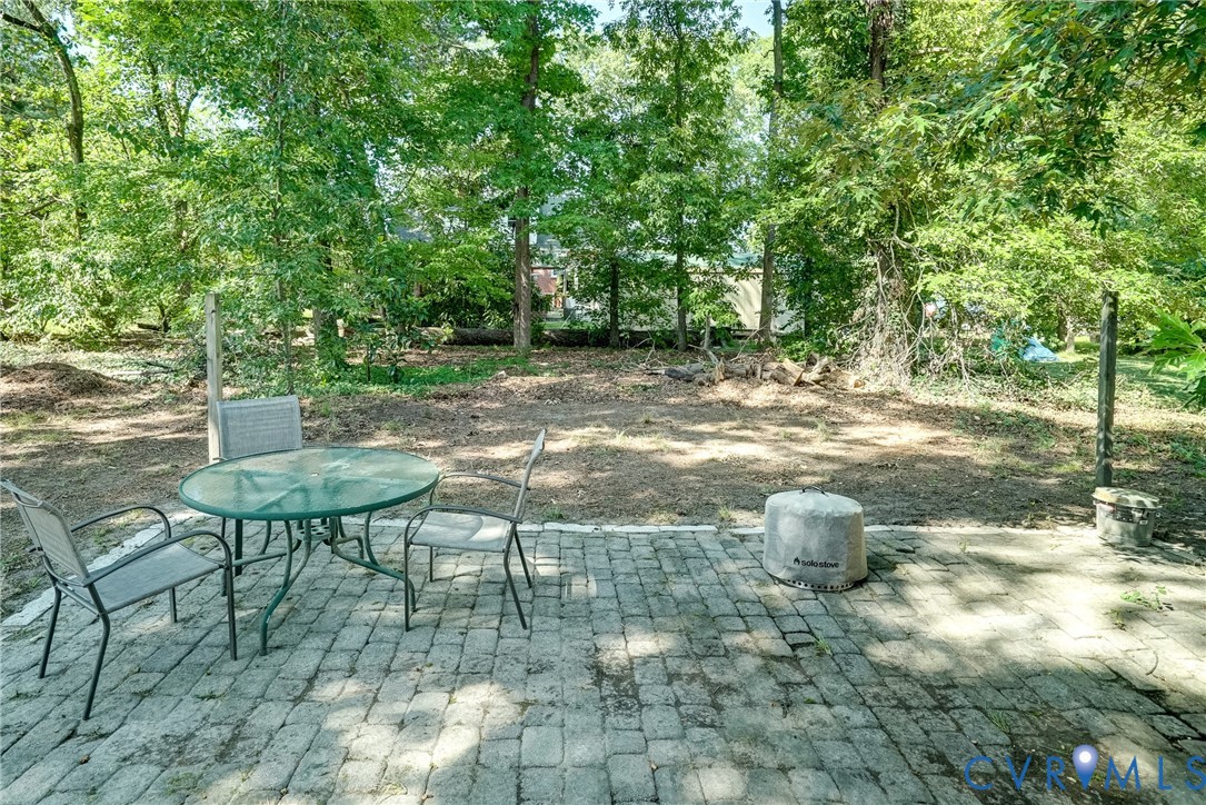 Paved patio area with a natural tree line backdrop