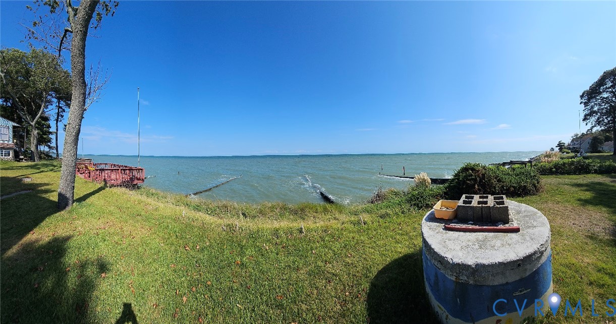 Waterfront property featuring expansive grassy areas and a clear horizon