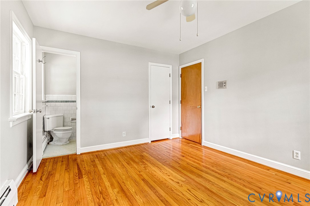 Hardwood flooring throughout, white trim, ceiling fan, and white painted walls