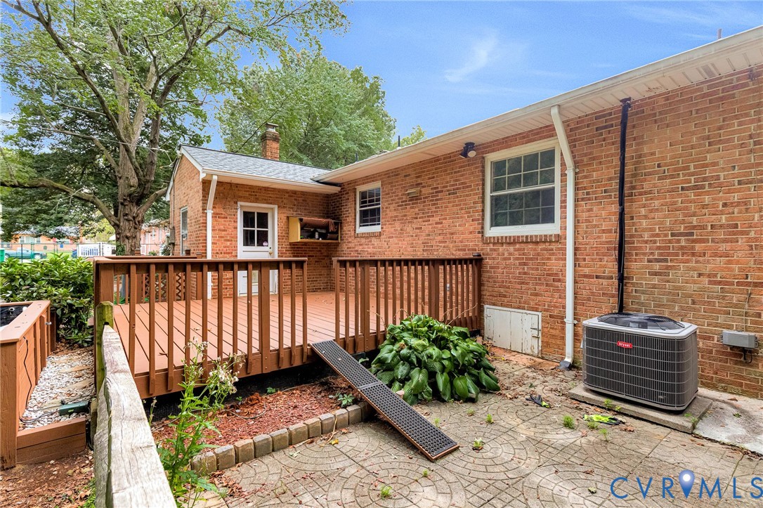 Expansive brick exterior with a wood-stained deck and an exterior door