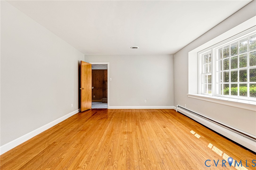 Hardwood flooring, light gray wall finishes, white trim, and a multi-pane window Hardwood flooring, light gray wall finishes, white trim, and a multi-pane window