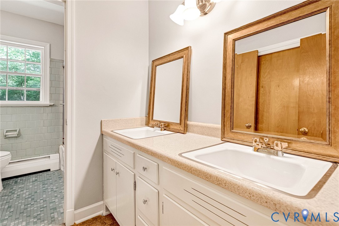 Dual vanity with integrated sinks, wood-finish framed mirrors, and white cabinetry