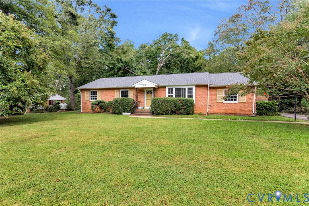 Brick exterior with a gabled roof and a spacious front lawn Brick exterior with a gabled roof and a spacious front lawn