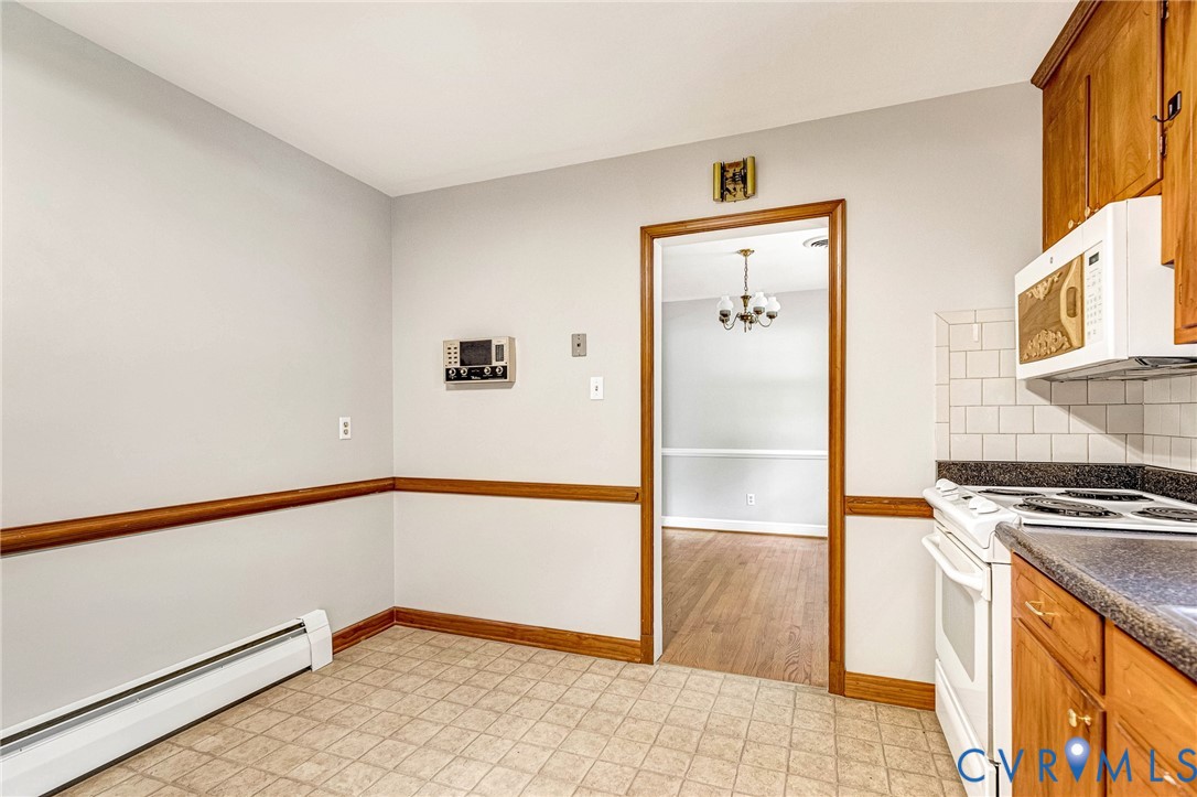 Kitchen featuring wood-finish cabinetry, white subway tile backsplash, and a built-in microwave Kitchen featuring wood-finish cabinetry, white subway tile backsplash, and a built-in microwave