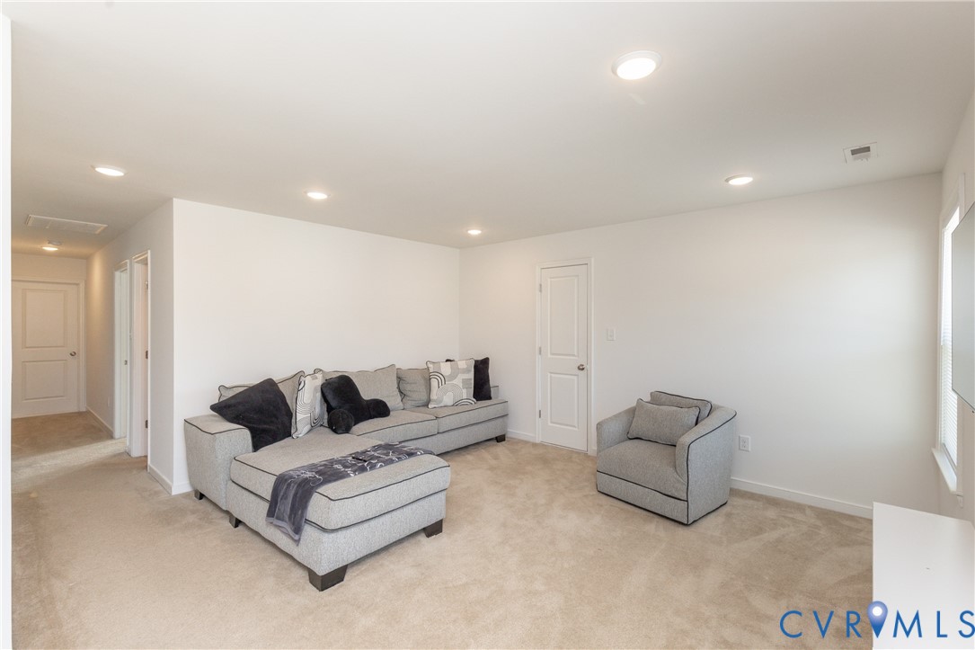 Recessed lighting, carpet flooring, a white interior door, and a window