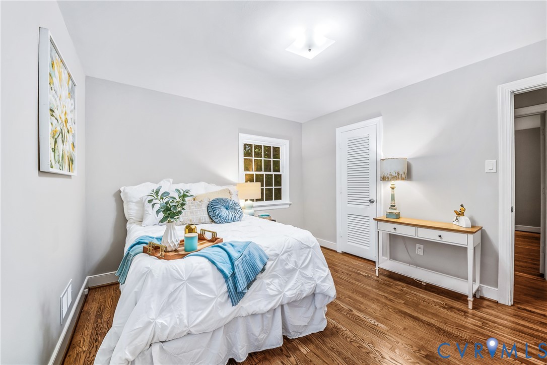 Hardwood-finish flooring, recessed lighting, window with exterior landscape, and a louvered door