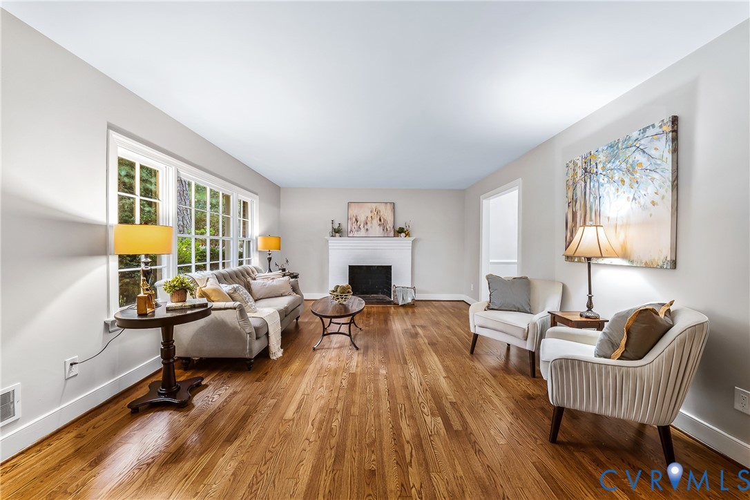 Hardwood flooring, white wall paint, multiple pane windows, white trim, and a built-in fireplace Hardwood flooring, white wall paint, multiple pane windows, white trim, and a built-in fireplace