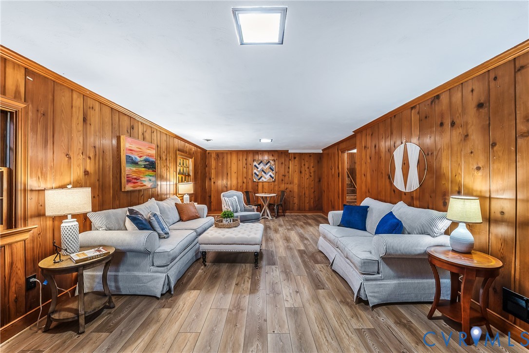 Wood-paneled walls defining a spacious room with wood-finish flooring