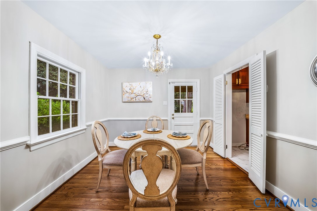 Hardwood-finish flooring, paneled interior door, and a multi-pane window