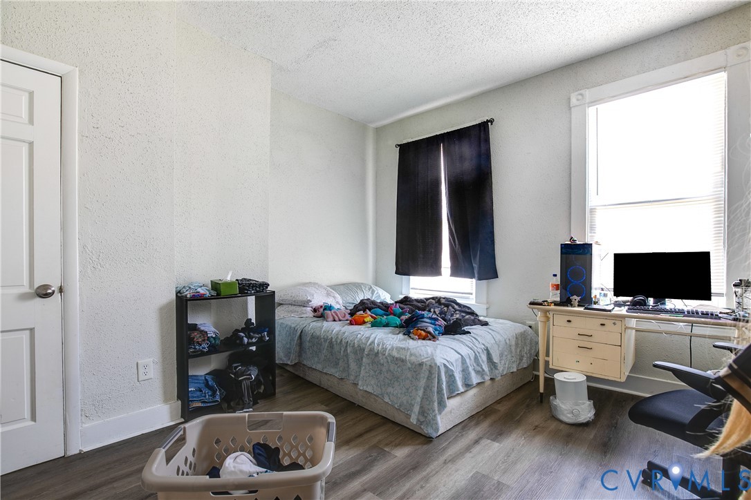 Wood-finish flooring, white paneled door, and two distinct window placements