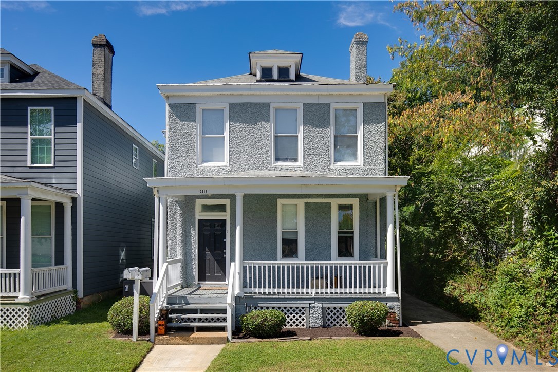 Two-story residence featuring a gray textured exterior, white trim, and a full-width front porch with white railings