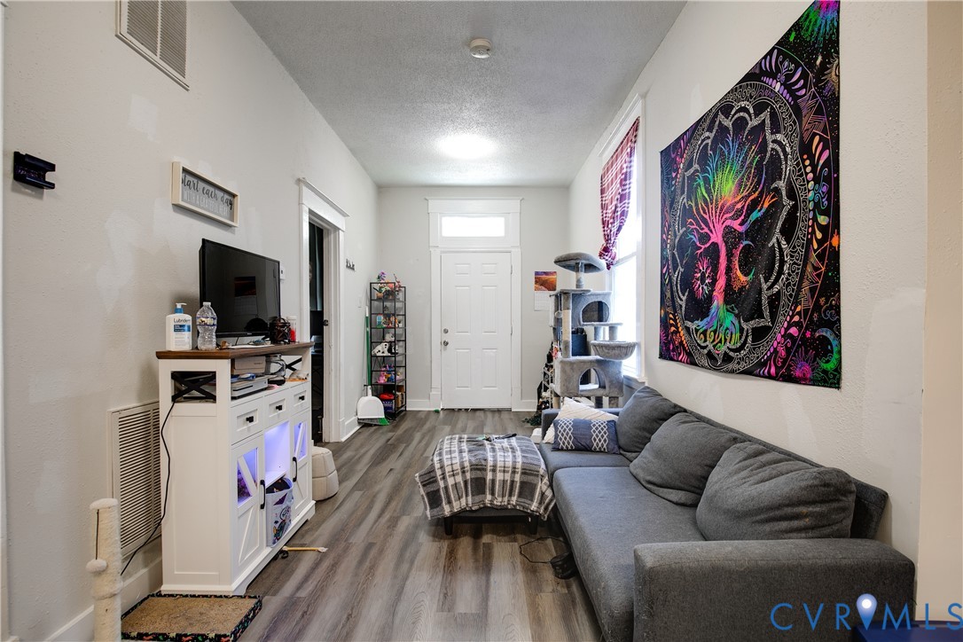 Wood-finish flooring, white door with transom window, white trim, recessed lighting, and light gray wall finish