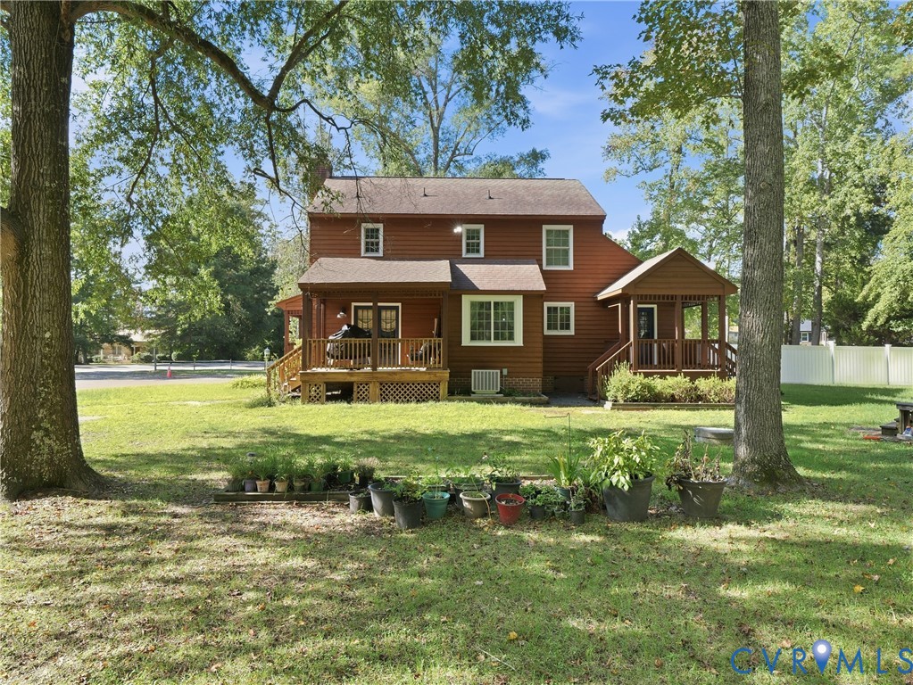 Two-story residence featuring wood siding, dual covered porches, and an expansive yard with mature trees Two-story residence featuring wood siding, dual covered porches, and an expansive yard with mature trees