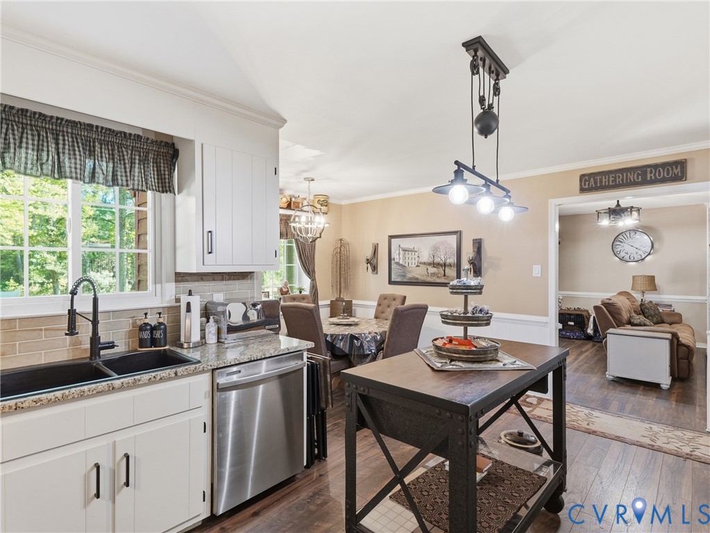 Kitchen featuring white cabinetry, stone-surface countertops, dual-basin undermount sink with a high-arch faucet, and wood-finish flooring