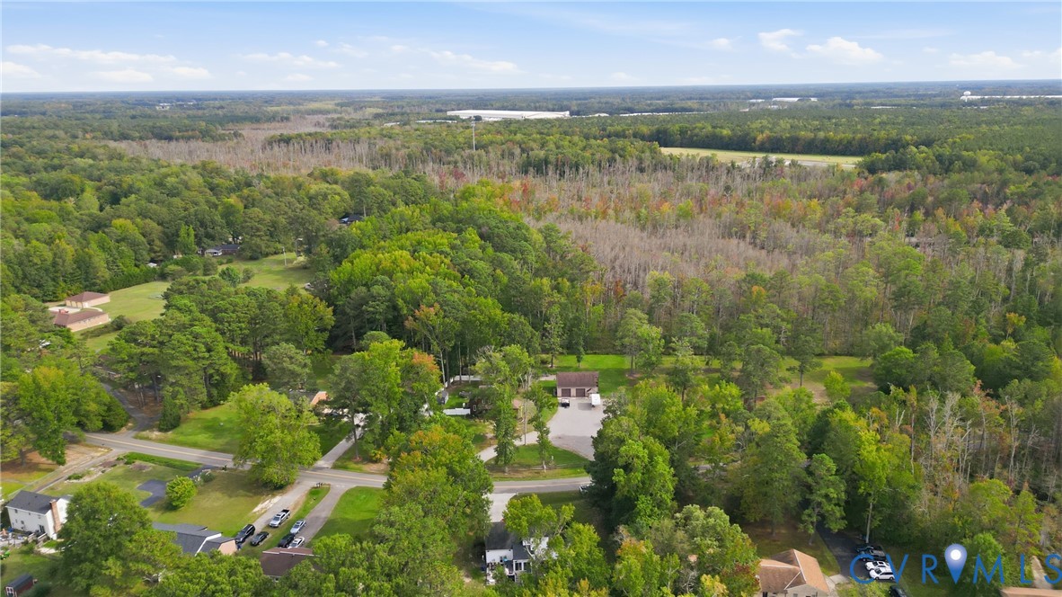Expansive wooded property with a detached garage and paved driveway
