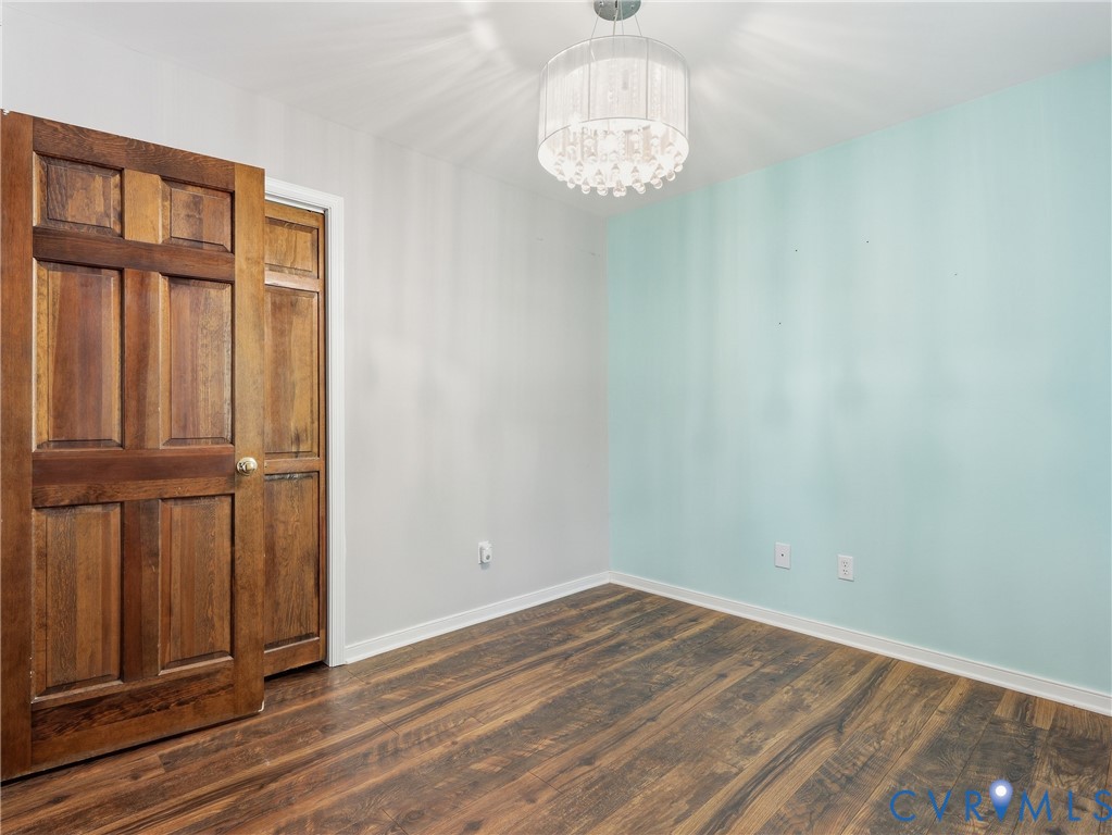 Wood-finish flooring, six-panel wood door, and tiered crystal-style drum pendant lighting