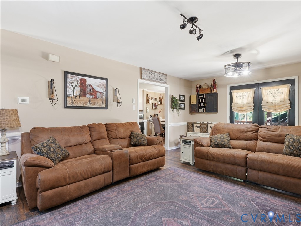 Interior living area featuring dark wood-finish flooring, recessed track lighting, a multi-light ceiling fan, and built-in wall cabinetry