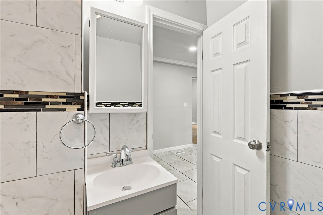 Vanity with an integrated sink, polished chrome faucet, and mirrored medicine cabinet