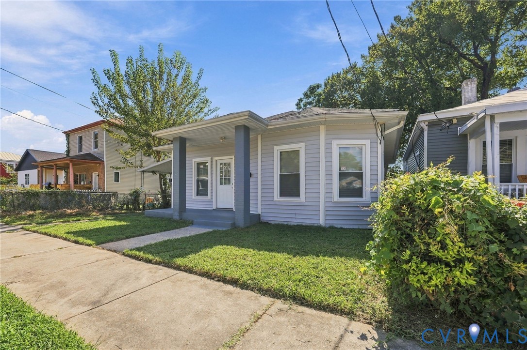 Light-colored siding exterior with a covered front porch featuring square columns